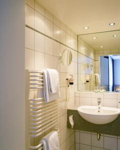 W łazience znajduje się umywalka i lustro. w obiekcie Maternushaus w Kolonii