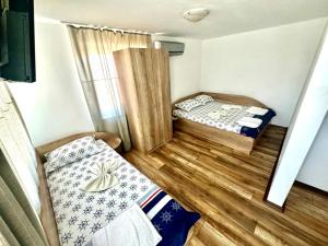 a small room with two beds and a mirror at Къща за гости ПЕРФЕКТО in Chernomorets