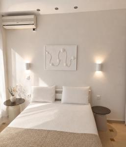 a bedroom with a white bed with two tables at Sea Sun in Plomari