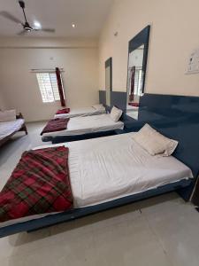 a room with three beds in a room with a mirror at Shada Shiv Heritage, Omkareshwar in Godarpura