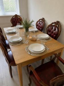 a wooden table with plates and wine glasses on it at Amy's place in Warrington +8 photos