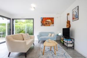 a living room with a couch and a chair at Villa Les Lodges Terre et Mer in Concarneau