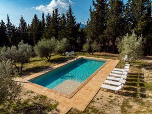 an outdoor pool with lounge chairs and a swimming pool at Villa Sara in Foligno
