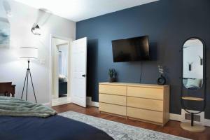 a bedroom with a tv on a blue wall at Cozy 3BR Coastal Retreat Private Yard & Fire Pit 5 Min to Beach! in Old Orchard Beach