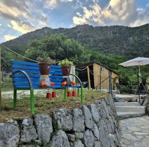 a blue bench with two flower pots on it at Sogni appesi in Valleluce-Cese