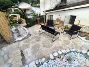 a patio with chairs and a table in a yard at Sogni appesi in Valleluce-Cese +7 photos