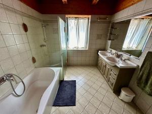 a bathroom with a tub and a sink and a bath tub at Apkó Vendégház in Őriszentpéter +22 photos