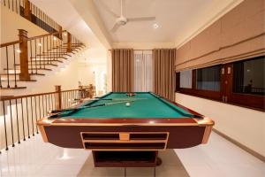 a pool table in a living room with stairs at 79 by TerraLume in Nugegoda