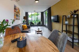 a living room with a wooden table and a couch at 't Eibernest in De Cocksdorp