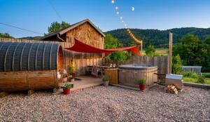a wooden cabin with a deck and a hot tub at Entre-parenthèses,gîte avec SPA,proche Gérardmer et La bresse in Vagney