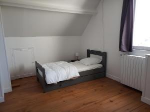 a bedroom with a bed with white sheets and a window at Gîte 10 Couchages À Barfleur in Barfleur