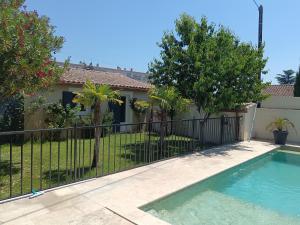 a fence around a swimming pool in front of a house at Charmant cocon tout équipé in Carpentras