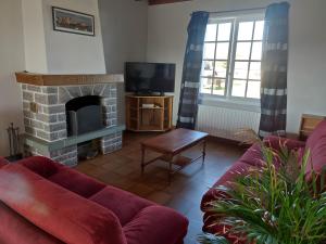 a living room with a couch and a fireplace at Gîte 10 Couchages À Barfleur in Barfleur