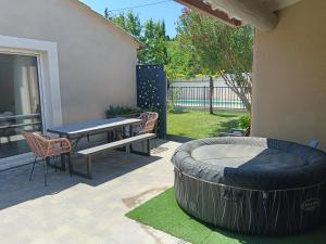 a patio with a table and a large tire at Charmant cocon tout équipé in Carpentras