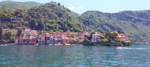 a town on the water in front of a mountain at I Tre Oleandri Varenna in Varenna