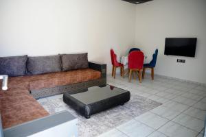 a living room with a couch and a table and chairs at Maison 100 in Douz