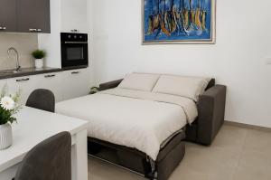 a bed in a room with a table and a kitchen at Casa vacanza Via Roma 103 in Crotone