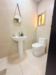 a bathroom with a toilet and a sink and a mirror at Modern Studios Apartments in Juffair and Exhibition in Manama +45 photos