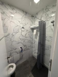 a bathroom with a toilet and a glass shower at HOTEL PERLA - Free Parking in Sarajevo +19 photos