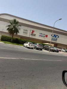 a large building with cars parked in front of it at Modern Studios Apartments in Juffair and Exhibition in Manama