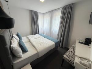 a small bedroom with a bed and a window at HOTEL PERLA - Free Parking in Sarajevo