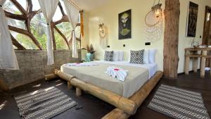 a bedroom with a bed made out of logs at MONEA The Nest in Paje +24 photos