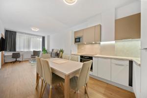 a kitchen and dining room with a table and chairs at Apartment Absolon in Komín