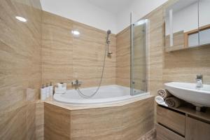 a bathroom with a shower and a tub and a sink at Apartment Absolon in Komín +25 photos