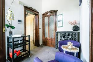 a living room with a blue chair and a table at Boutique Casa Giulietta Desenzano in Desenzano del Garda