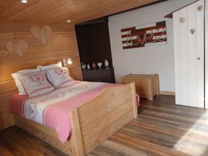a bedroom with a bed with a wooden wall at Entre-parenthèses,gîte avec SPA,proche Gérardmer et La bresse in Vagney