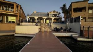 a dock leading to a house in the water at Best Riverfront Parker Home in Parker