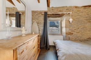 a bedroom with a bed and a dresser and a window at Gite Ti Arzou in Le Conquet