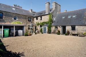 an old stone house with a gravel driveway at Gite Ti Arzou in Le Conquet