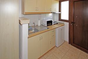 a small kitchen with a sink and a microwave at Studios Stella Vourvourou in Vourvourou