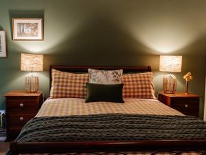 a bedroom with a bed with two night stands and two lamps at Green Gables Bed and Breakfast in Cygnet