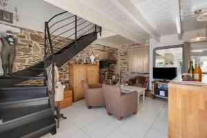 a living room with a spiral staircase and a table and chairs at La maisonette Ti Arzou in Le Conquet