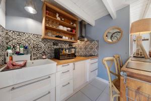 a kitchen with white cabinets and blue walls at La maisonette Ti Arzou in Le Conquet +12 photos