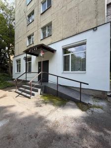 a white building with a staircase in front of it at Atlas Hotel in Poltava