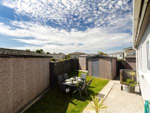 a small garden with a table and chairs on a patio at Lazy Daize in Saint Merryn