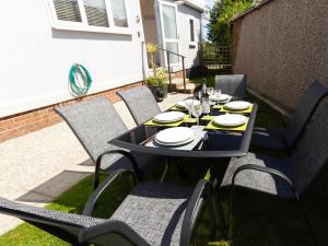 a black table and chairs with plates and glasses on it at Lazy Daize in Saint Merryn