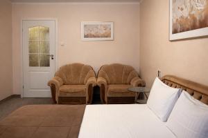 a hotel room with two chairs and a bed at Apartment Deluxe on Moscow Avenue in Chişinău