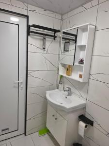 a white bathroom with a sink and a mirror at Апартамент Туида 2 in Sliven +18 photos