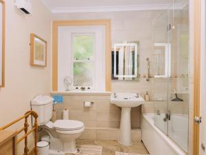 a bathroom with a toilet and a sink and a tub at Tŷ Melindwr in Capel Bangor
