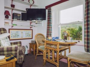 a living room with a table and chairs and a window at Tŷ Melindwr in Capel Bangor