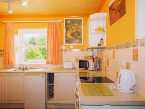 a kitchen with yellow walls and a counter top at Tŷ Melindwr in Capel Bangor +35 photos