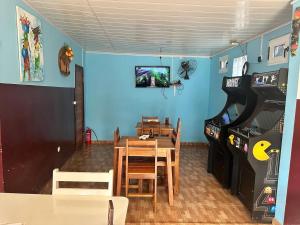 a dining room with a table and a video game at Pensão Aragão & Lima in São Tomé