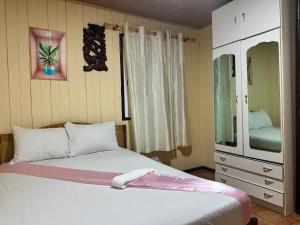 a small bedroom with a bed and a dresser at Pensão Aragão & Lima in São Tomé