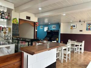 a bar in a restaurant with a table and chairs at Pensão Aragão & Lima in São Tomé