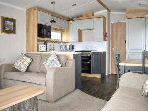 a living room with a couch and a kitchen at Apple Grove 110 - Ukc9393 in Exmouth