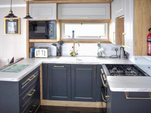 a kitchen with blue cabinets and a sink at Apple Grove 110 - Ukc9393 in Exmouth
